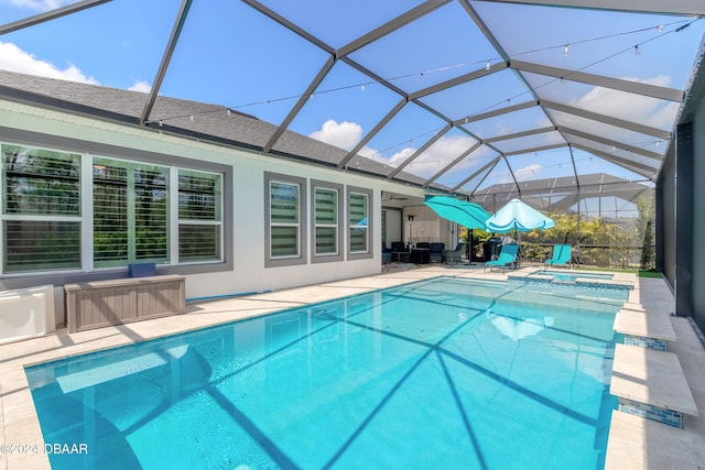 view of swimming pool featuring a patio area, a lanai, ceiling fan, and an in ground hot tub