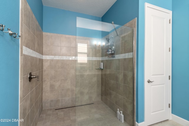 bathroom with tiled shower and a textured ceiling