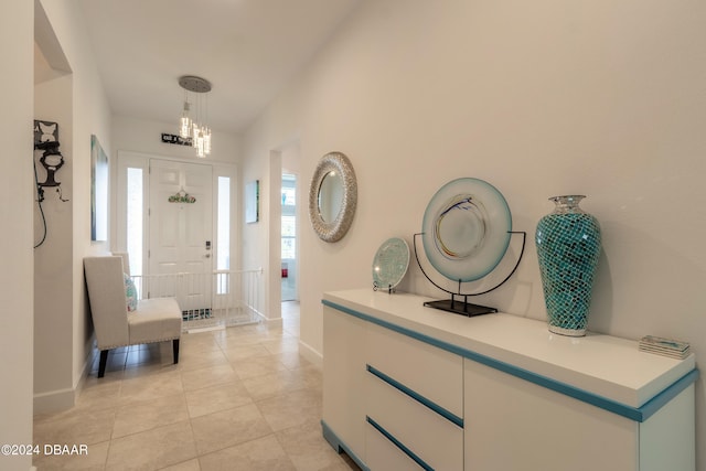 tiled entryway with an inviting chandelier