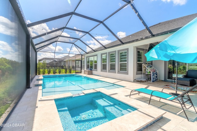 view of pool with a lanai, an in ground hot tub, and a patio area