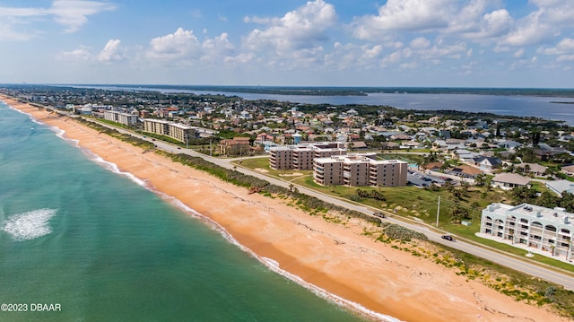 drone / aerial view featuring a beach view and a water view