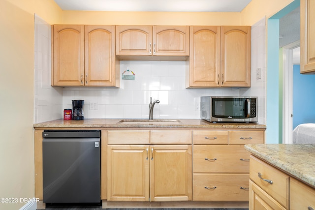 kitchen featuring sink, light stone counters, appliances with stainless steel finishes, light brown cabinetry, and decorative backsplash