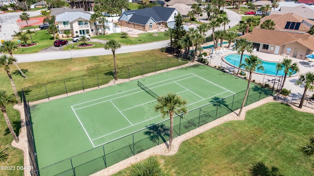 view of tennis court with a community pool