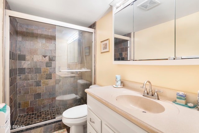 bathroom featuring vanity, toilet, and a shower with shower door