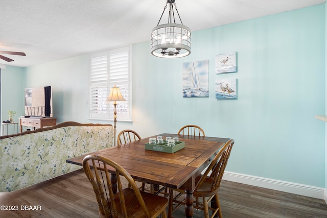 dining area featuring dark hardwood / wood-style floors, a textured ceiling, and ceiling fan with notable chandelier