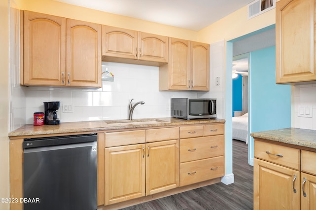 kitchen with dark wood-type flooring, sink, light stone countertops, appliances with stainless steel finishes, and light brown cabinetry