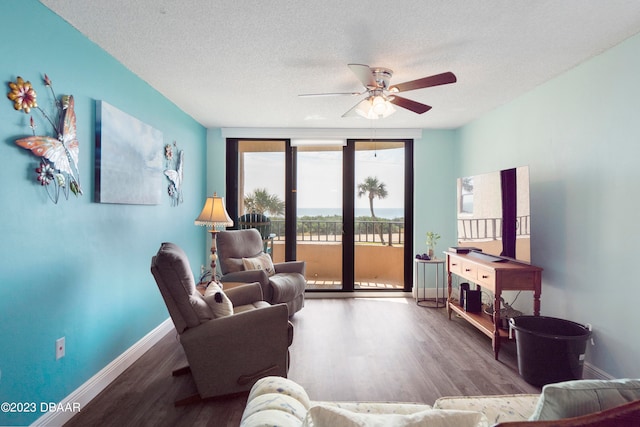 living room featuring a textured ceiling, hardwood / wood-style flooring, floor to ceiling windows, and ceiling fan