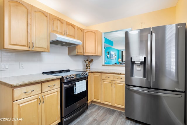 kitchen featuring light brown cabinets, appliances with stainless steel finishes, hardwood / wood-style flooring, and light stone counters