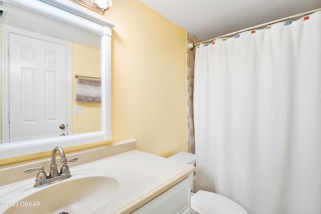 bathroom with curtained shower, vanity, and toilet