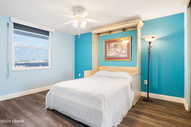 bedroom with ceiling fan, a textured ceiling, and dark hardwood / wood-style flooring