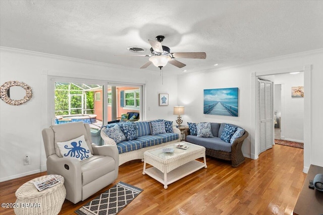 2667 John Anderson Dr, Ormond Beach, FL 32176 - living room featuring ceiling fan, ornamental molding, light wood-style floors, and a textured ceiling
