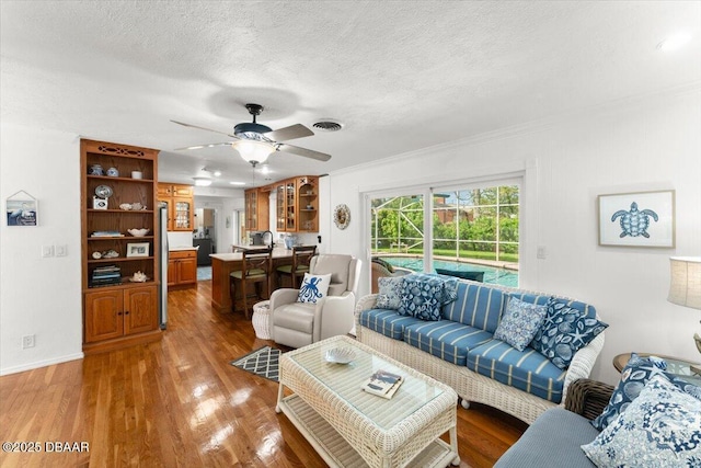 2667 John Anderson Dr, Ormond Beach, FL 32176 - living area with ceiling fan, wood finished floors, a textured ceiling, and crown molding