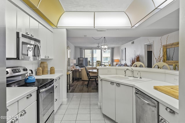 4555 S Atlantic Ave Unit 4209, Ponce Inlet, FL 32127 - kitchen with appliances with stainless steel finishes, light countertops, open floor plan, white cabinetry, and a chandelier
