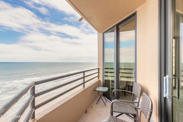 balcony featuring a water view and a beach view