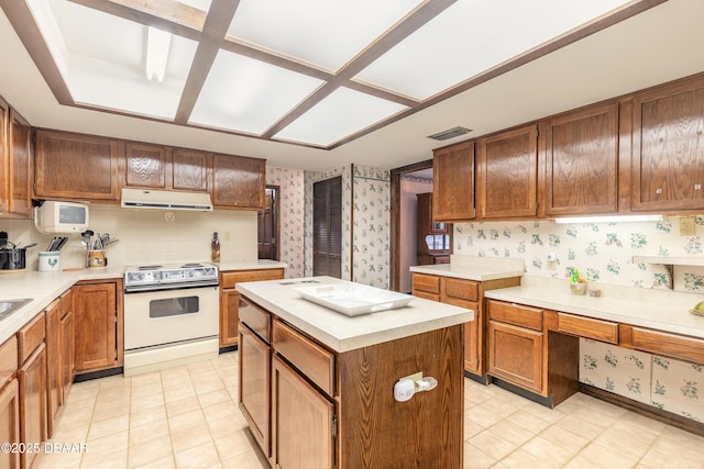 kitchen with electric stove, wallpapered walls, light countertops, range hood, and a center island