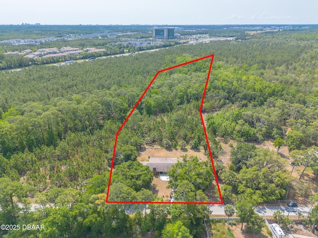 aerial view of property's location with a heavily wooded area and property parcel outlined