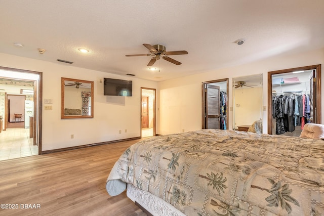bedroom with light wood finished floors, baseboards, recessed lighting, a textured ceiling, and ceiling fan
