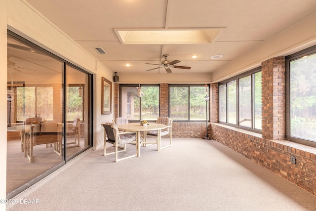 sunroom / solarium with carpet flooring, a ceiling fan, brick wall, and recessed lighting