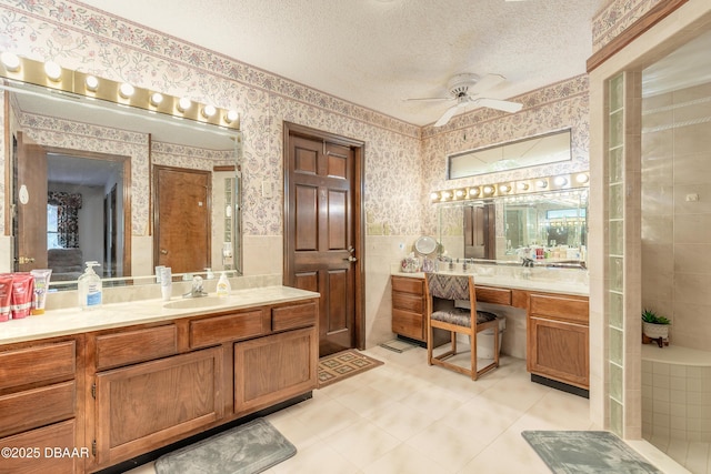 full bathroom featuring wallpapered walls, tile walls, a wainscoted wall, a textured ceiling, and tile patterned floors