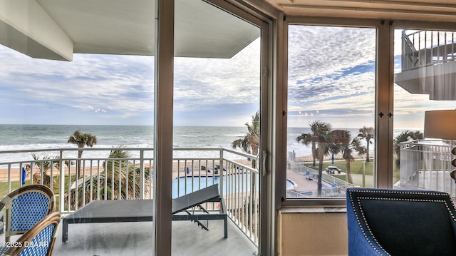 balcony featuring a water view and a beach view