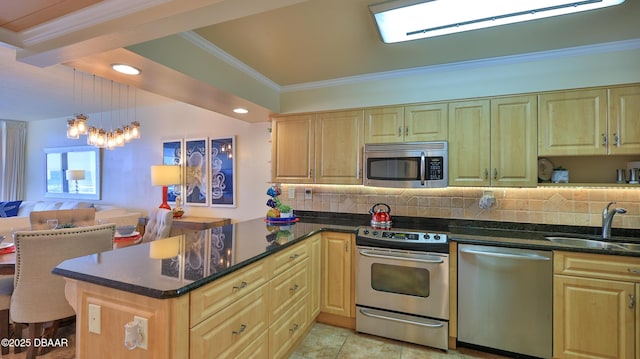 kitchen with kitchen peninsula, stainless steel appliances, backsplash, decorative light fixtures, and sink