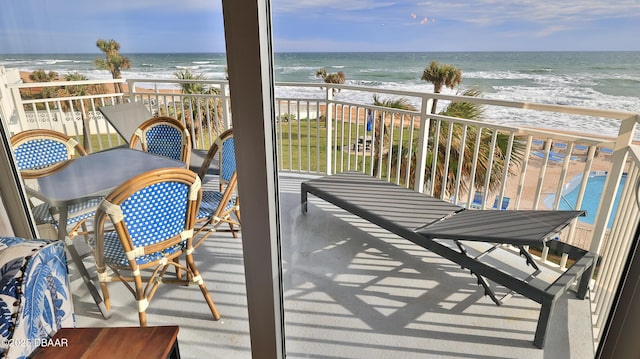 balcony with a water view and a beach view