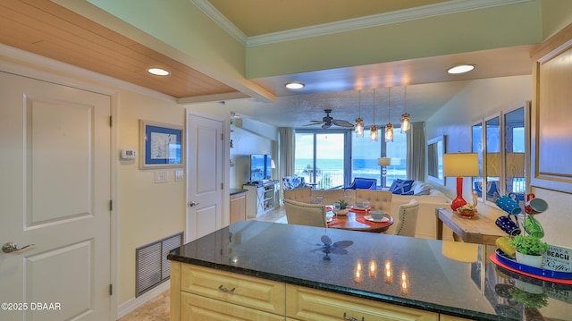 kitchen with ceiling fan, crown molding, hanging light fixtures, light tile patterned floors, and dark stone counters