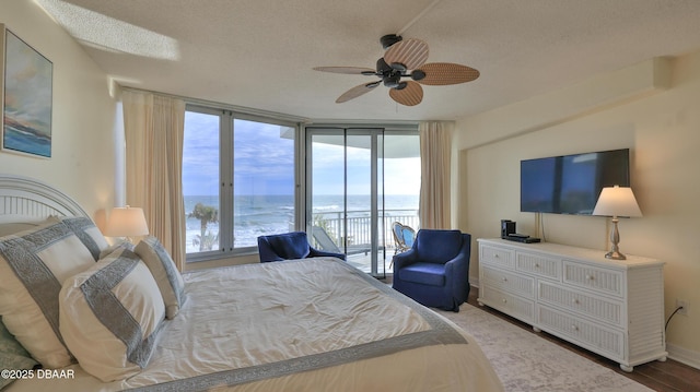 bedroom featuring floor to ceiling windows, access to exterior, a textured ceiling, and multiple windows