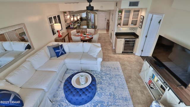 tiled living room with ceiling fan and beverage cooler