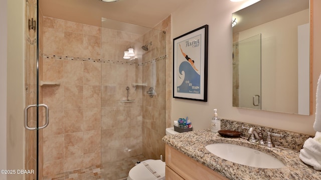 bathroom featuring a shower with door, toilet, and vanity