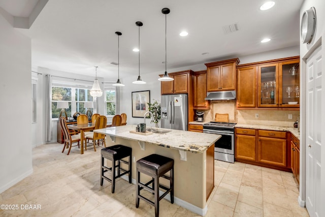 6 Promenade Pl, Palm Coast, FL 32164 - kitchen featuring appliances with stainless steel finishes, under cabinet range hood, brown cabinets, decorative backsplash, and recessed lighting