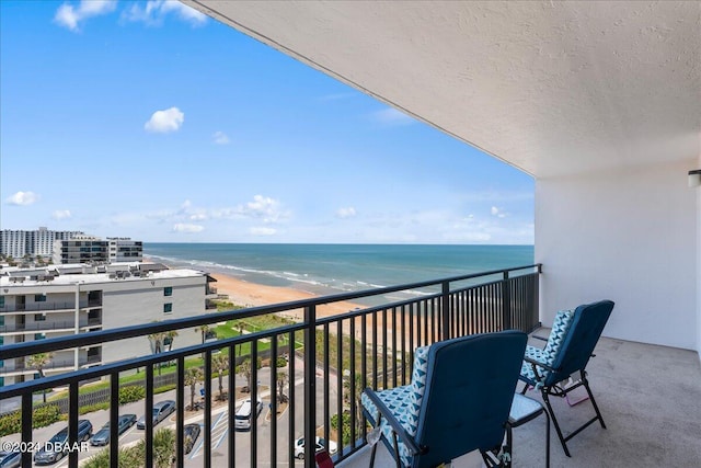 balcony featuring a water view and a view of the beach