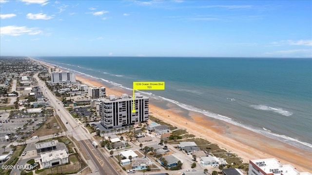 birds eye view of property with a water view and a beach view