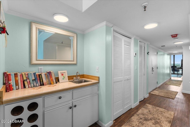 bathroom featuring wood-type flooring, vanity, and ornamental molding