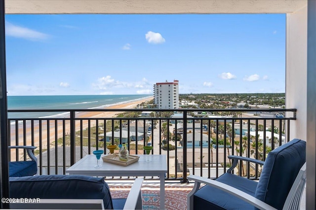 balcony with a water view and a view of the beach