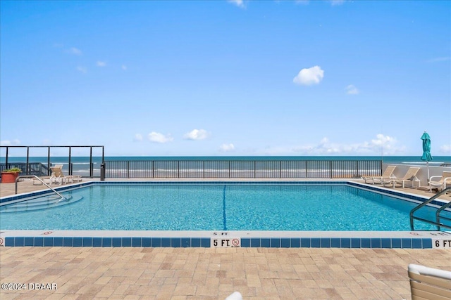 view of swimming pool with a water view and a patio area