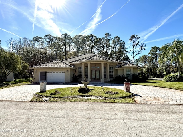 view of front facade featuring a garage, french doors, and a front lawn