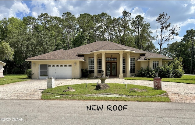 47 Elder Dr, Palm Coast, FL 32164 - view of front facade with french doors, decorative driveway, stucco siding, a garage, and a front lawn