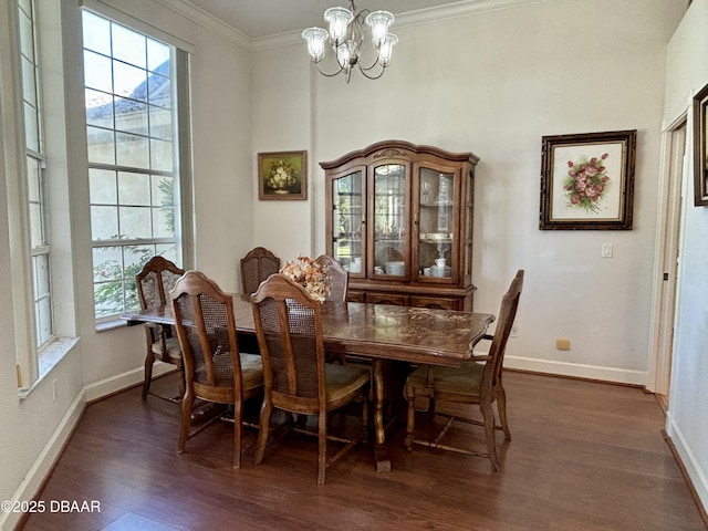 dining area with dark hardwood / wood-style flooring, an inviting chandelier, a wealth of natural light, and ornamental molding