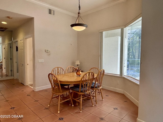 tiled dining room featuring ornamental molding