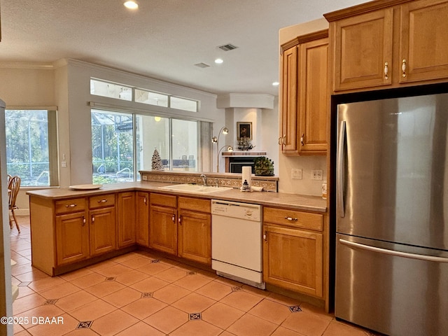 kitchen featuring stainless steel refrigerator, sink, white dishwasher, and light tile patterned floors