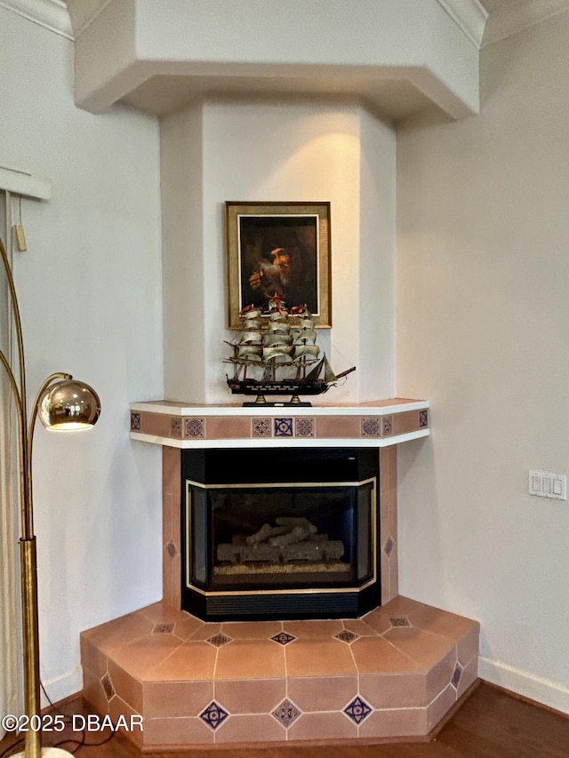 details featuring hardwood / wood-style floors and a tiled fireplace