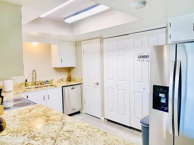 415 Banana Cay Dr Unit J, South Daytona, FL 32119 - kitchen featuring appliances with stainless steel finishes, white cabinetry, light wood-type flooring, and light stone countertops