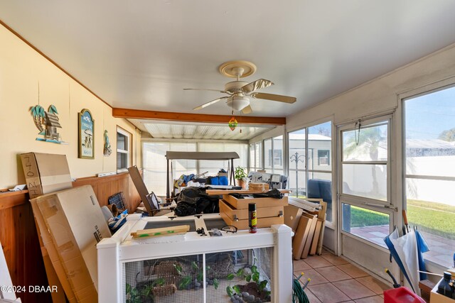 sunroom featuring beam ceiling, ceiling fan, and a healthy amount of sunlight