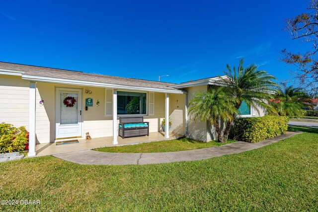 ranch-style home with a porch and a front lawn