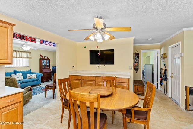 dining room with a textured ceiling, ceiling fan, and crown molding