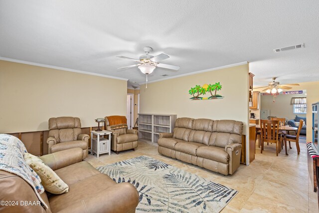 living room featuring a textured ceiling, ceiling fan, and crown molding