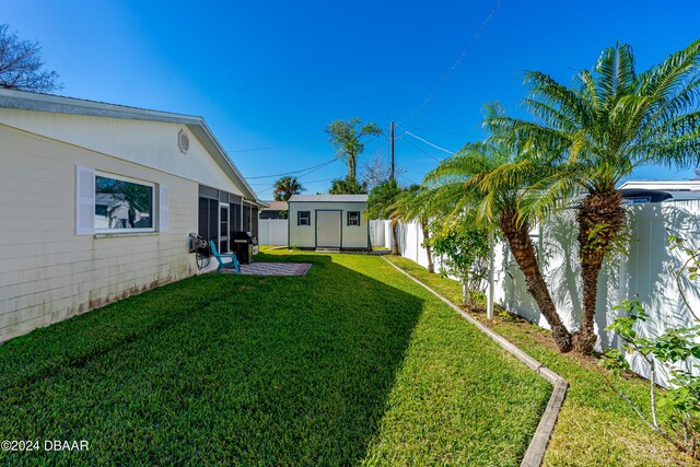 view of yard featuring a storage unit and a patio area