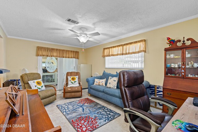 home office with a textured ceiling, carpet floors, ceiling fan, and crown molding