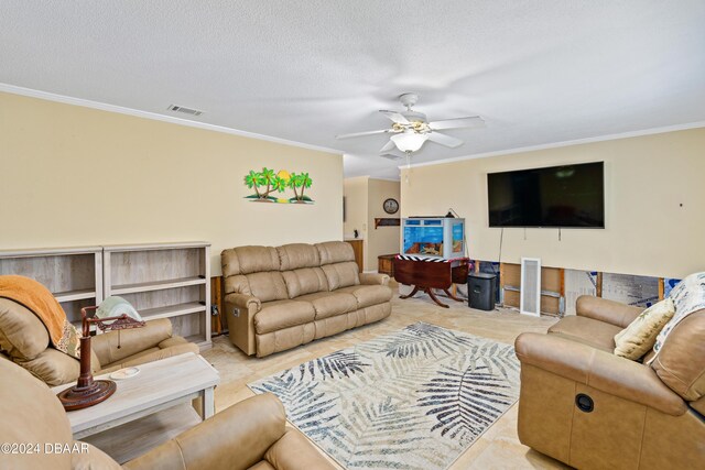 tiled living room with a textured ceiling, ceiling fan, and ornamental molding